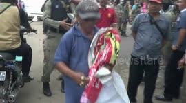 Lone fruit seller rages against dozens of officers dismantling his store