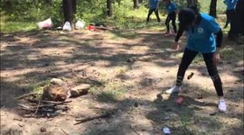 Campers swing cucumbers to hit cans in race