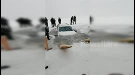 Moment ice cracks as couple drive on frozen lake in China and car slips into water