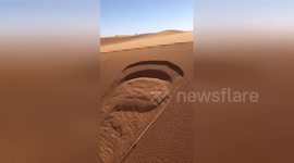 Slight ripple on sand dunes in Sahara creates miniature avalanche