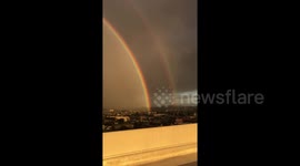 Spectacular double rainbow arcs over Los Angeles cityscape