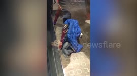 This is the moment a woman saw a street beggar asking for cash - while watching TV on a tablet computer