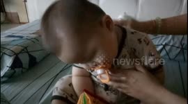 Tired baby falling asleep while mom burping him