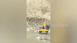 Local people transported by JCB across river to escape landslide in north India