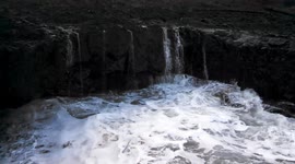 Bad weather rain storm causes ocean waves to crash into cliff