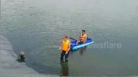 Rescue worker swims across deep reservoir to save drowning dog