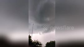 People watch a destructive whirlwind form above their heads in Indonesia