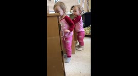 Twin girl tries to talk on an old phone