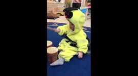 Toddler dressed up as a bee playing bongos