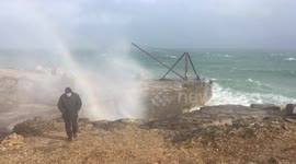 Storm Freya waves create beautiful sea water rainbow over Dorset cliff