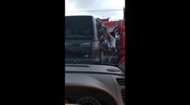 A man shaking the car to flow gasoline to the tank