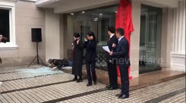Cartoonish scene as man interrupts ceremony by walking into glass door, smashing it to the ground
