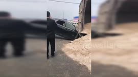 广西玉林一货车侧翻压到小轿车 附近群众砸窗救出司机