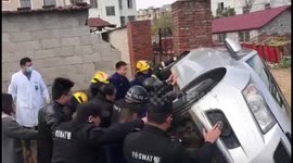 Rescue workers and passersby team up to lift car up and free trapped woman