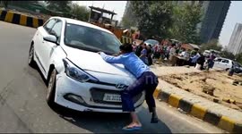 Man clings onto bonnet of car as driver speeds through traffic in northern India