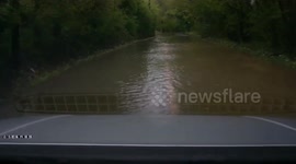 Car drives through flooded UK country road