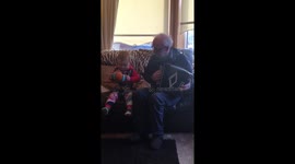 2 year old baby playing accordion with granddad