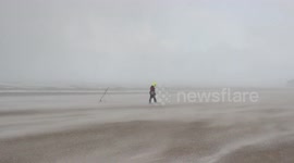 Lone fisherman blasted by horizontal hails on Northern Ireland beach