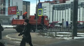 Workers in Russia efficiently grit roads from on top of their moving truck