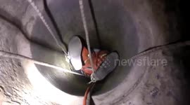 Fireman hangs upside-down to save old woman trapped in well in China’s Henan