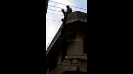 Dumb thief stuck dangling from top of building is rescued by police