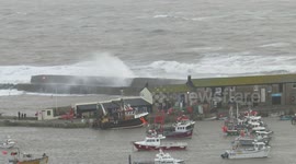 Waves breaking over the harbour wall in Lyme Regis during storm Freya