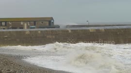 Waves break over harbour wall in Lyme Regis during Storm Freya