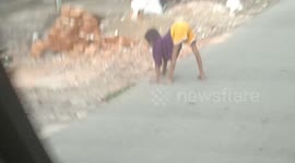 Handicapped child seen walking on all fours through Indonesian town