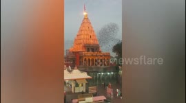 Birds flock in spiral formation around Hindu temple