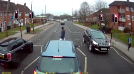 Car speeds through red light, narrowly missing pedestrian!