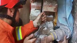 Firefighters tear open brick wall to free boy trapped in narrow gap inside