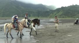 Black-flowing rivers after beach flooding in the shadows of Indonesia's Mount Bromo