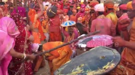 Indian women beat men hiding under cushions with sticks during Holi