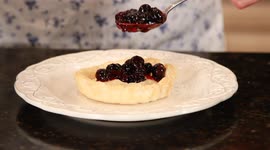 Woman Puts Blueberry Filling In Tart Cup
