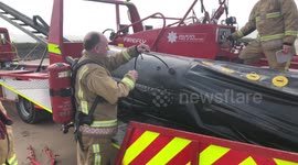 Firemen use BA sets to inflate the curtain on their hovercraft.