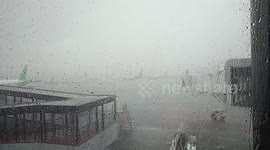 Business as usual at Jakarta airport despite howling wind and rain