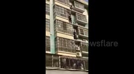 Heroic men climb four floors on building exterior to rescue child hanging from window