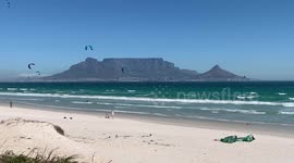 Stunning scene as kitesurfers catch the air with Table Mountain as backdrop