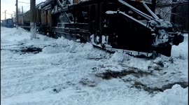 Train ploughs through snow and ice on tracks during a freezing Russian winter