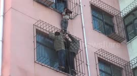 Chinese firemen rescue boy hanging from fourth-floor window of residential building