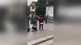 Chinese granny uses pointy finger on statue to scratch her back