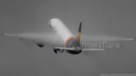 Condensation clouds engulf plane's wings as it takes off from Manchester Airport