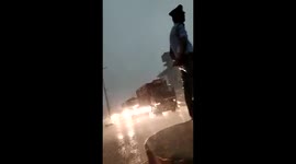 Neither wind nor rain stops this Indian traffic cop from doing his job
