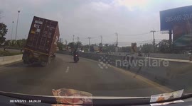 Quick-thinking Thai motorbike rider narrowly avoids being crushed by 40ft-long shipping container