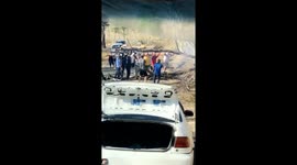 Group of people work together to try and move a tree on the road in Costa Rica which fell due to wildfires.