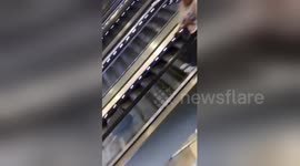 Clumpsy friend drops her luggage down a fleet of escalators
