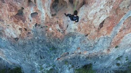 flying up shot of extreme rock climber (drone)