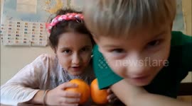 Funny children make orange juice