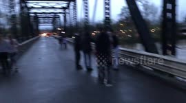 Crowds Walk Closed Bridge In Oregon As Flooding Continues