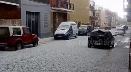 Unseasonal hailstorm pummels cars parked on a street in Barcelona